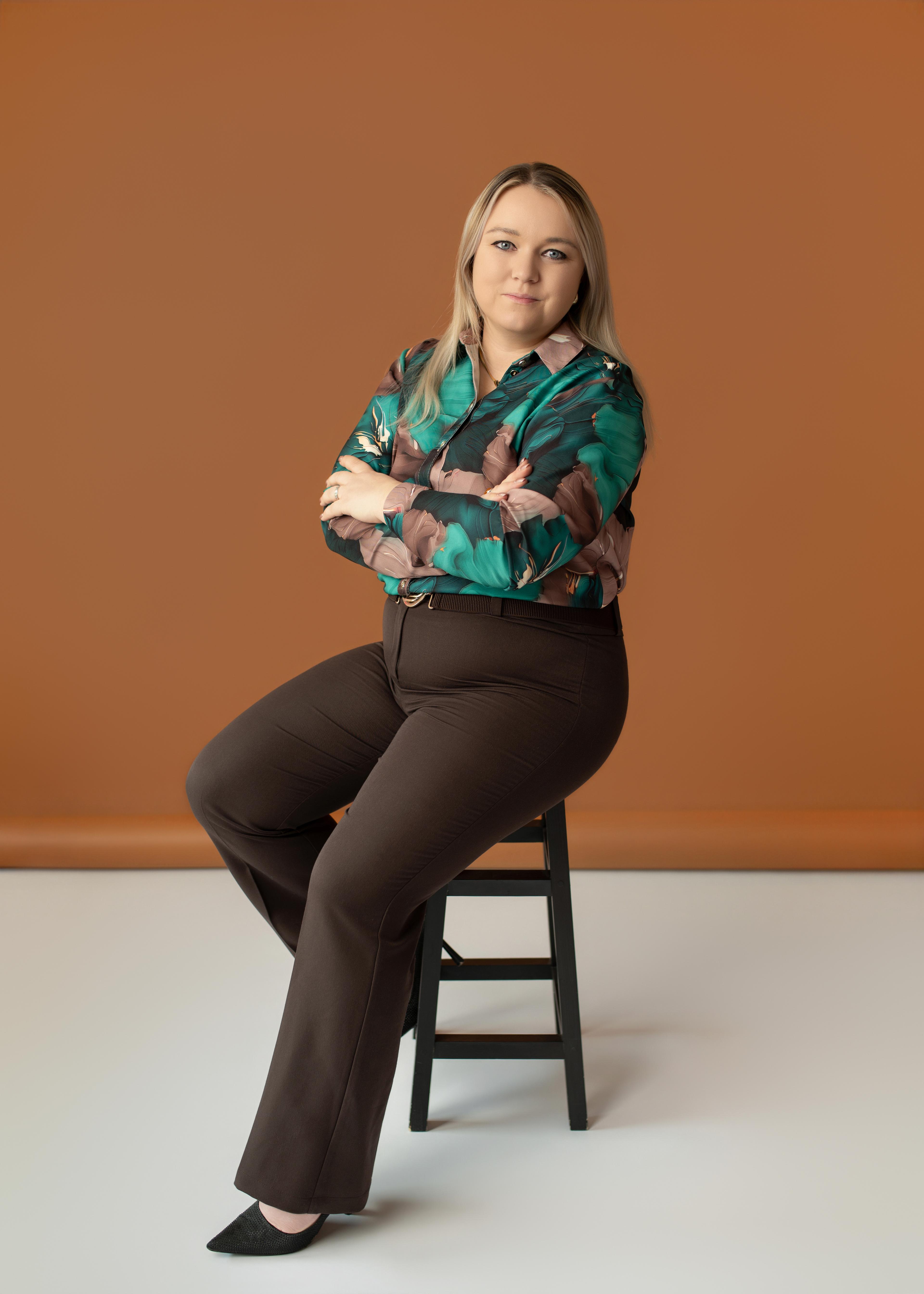 Jolanta Rzadkosz - founder and accountant at TaxMind, seated on a chair in her office